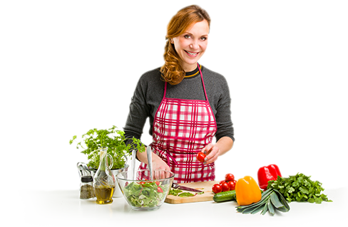 Femeie cu șorț de bucătărie care taie legume